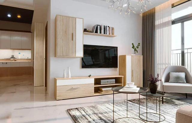 Un salón moderno con muebles de madera clara, un televisor colgado en la pared y un sillón de color gris claro. La luz del sol entra a raudales por los grandes ventanales, creando un ambiente acogedor.