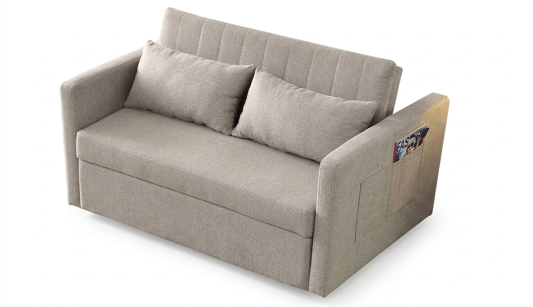 Sofá de dos plazas en color beige, con líneas limpias y modernas y dos cojines. En un bolsillo lateral se ve una revista, lo que le da un toque funcional.