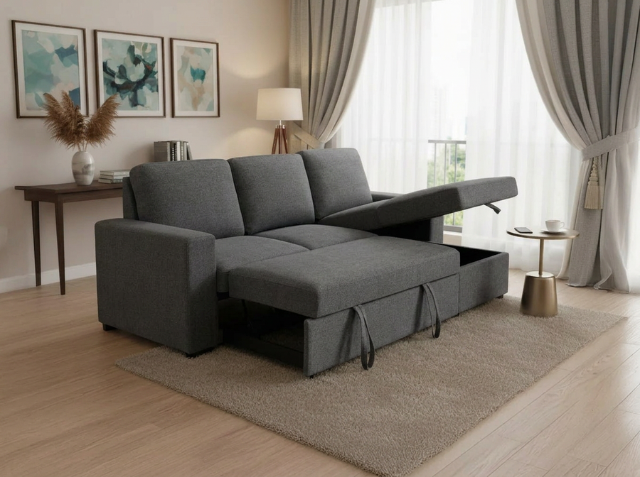 Sofá modular gris con cama extraíble en un salón moderno. El suelo de madera clara, la alfombra de tonos neutros, el arte abstracto y las cortinas suaves crean un ambiente acogedor.
