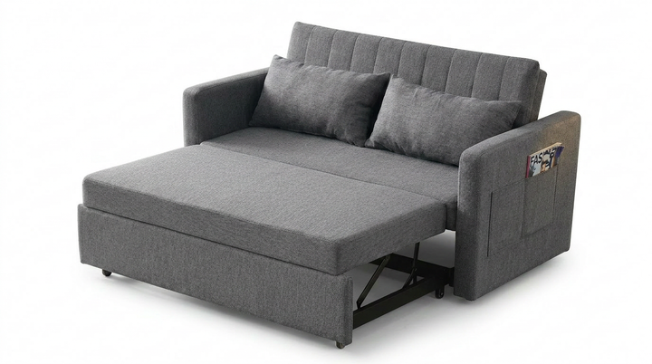 Sofá cama gris de diseño moderno, que se despliega para convertirse en cama. Cuenta con dos cojines grises y un bolsillo lateral para revistas.