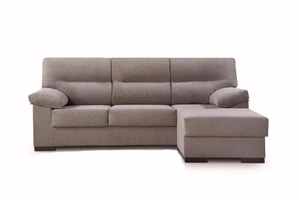 Un moderno sofá beige en forma de L, con mullidos cojines y amplios reposabrazos, destaca sobre un fondo blanco liso, transmitiendo comodidad y sencillez.