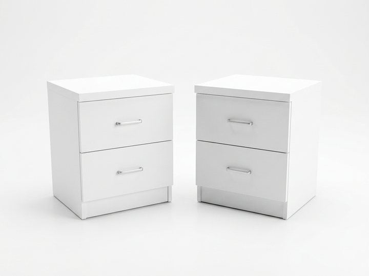 Dos mesitas de noche blancas idénticas, con dos cajones cada una y elegantes tiradores metálicos. Están colocadas una al lado de la otra sobre un fondo blanco liso.