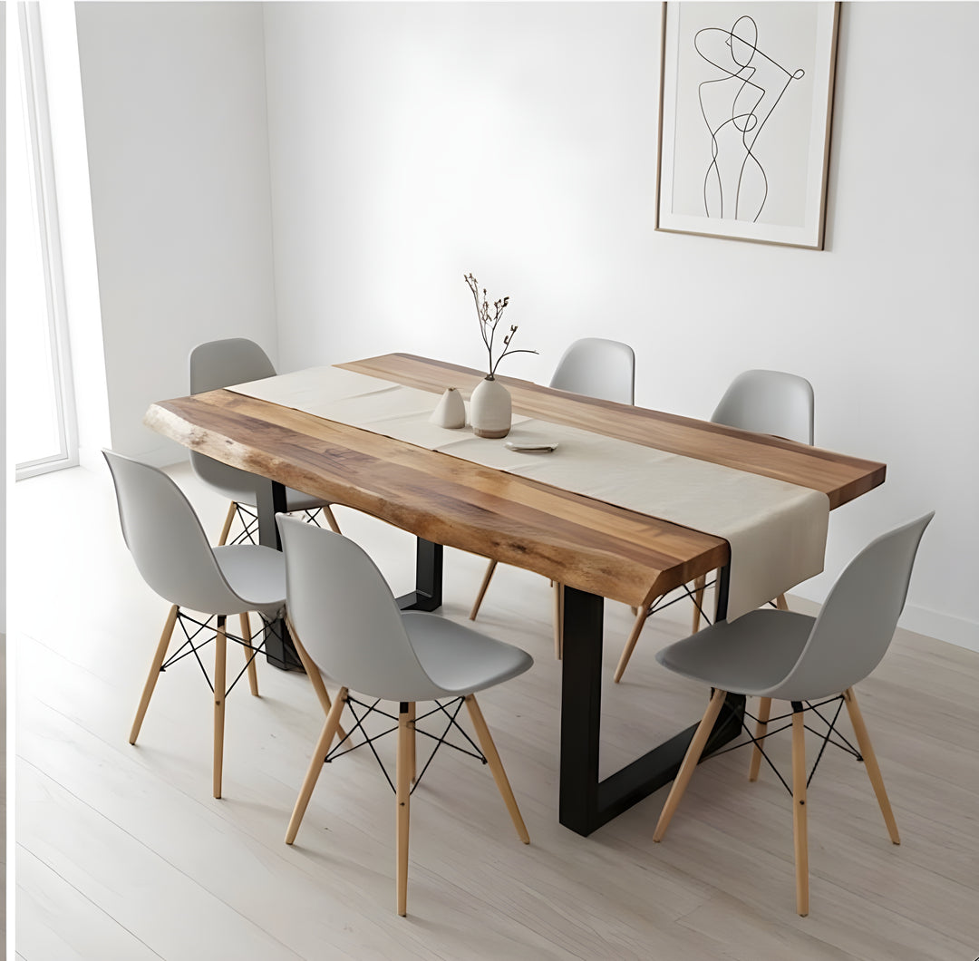 Comedor moderno con una mesa de madera con un camino de mesa beige, rodeada de seis sillas grises. Decoración minimalista en las paredes y un ambiente luminoso y diáfano.