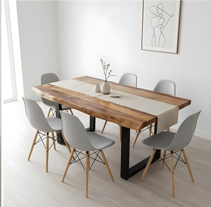 Comedor moderno con una mesa de madera con un camino de mesa beige, rodeada de seis sillas grises. Decoración minimalista en las paredes y un ambiente luminoso y diáfano.