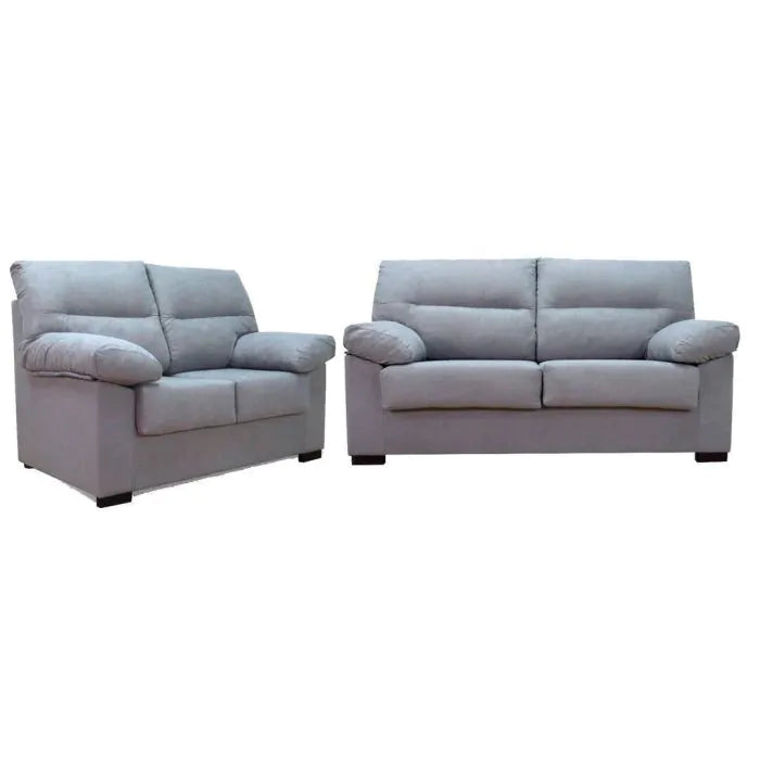 Hay dos sofás grises y mullidos uno al lado del otro: uno de dos plazas a la izquierda y otro de tres plazas a la derecha. Tienen cojines gruesos y patas cuadradas negras.