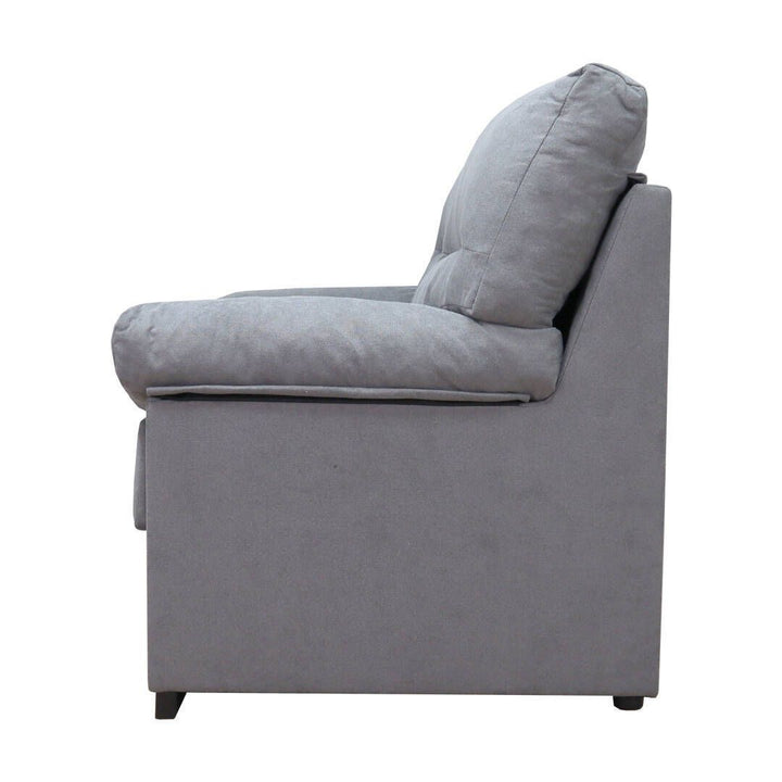 Vista lateral de un moderno sillón gris con mullidos cojines y un diseño minimalista. Transmite comodidad y sencillez, en contraste con un fondo blanco.