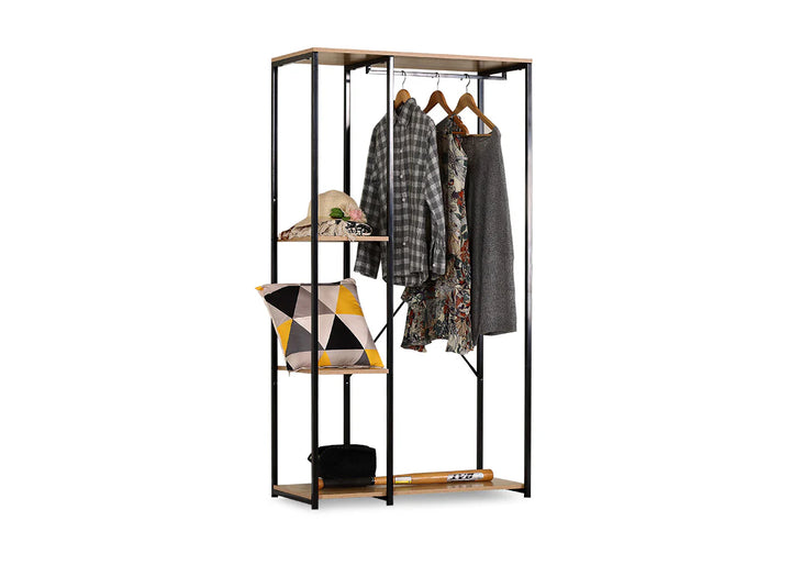 Armario abierto de estilo minimalista con estructura de metal negro y estantes de madera. En él hay ropa colgada, un cojín geométrico, un sombrero y un bate de béisbol.