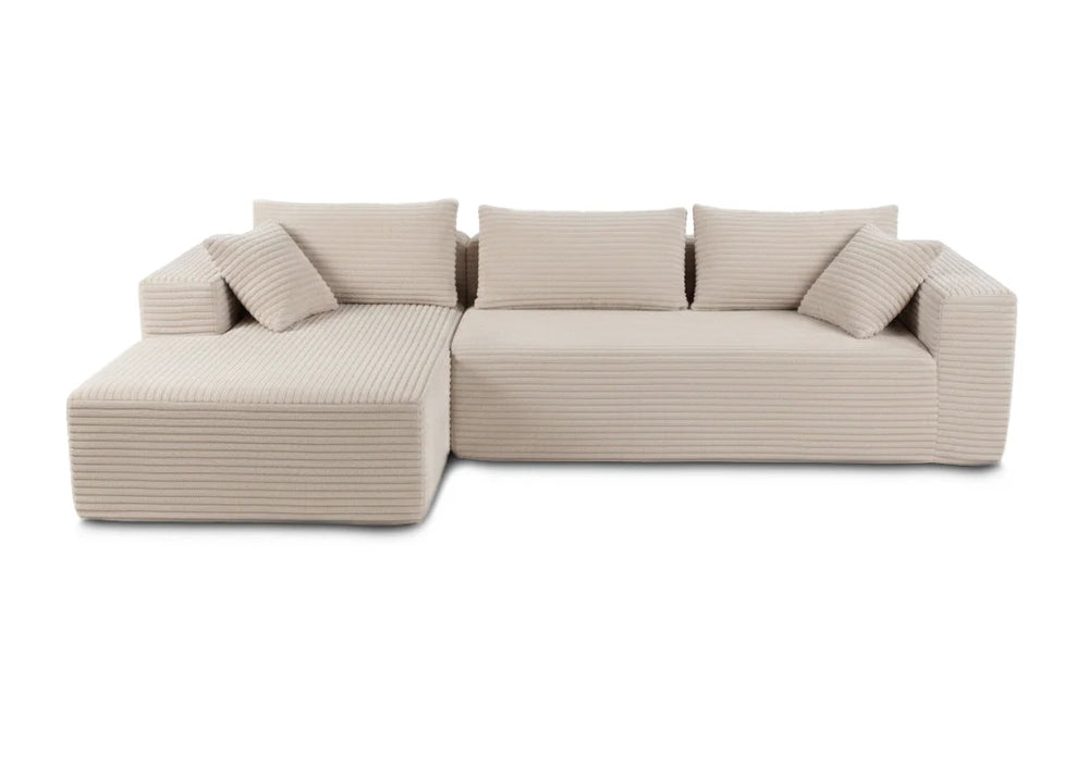 Un moderno sofá modular de color beige con un diseño acanalado y texturizado. Presenta una forma en L con múltiples cojines, lo que le confiere un aspecto acogedor y atractivo.