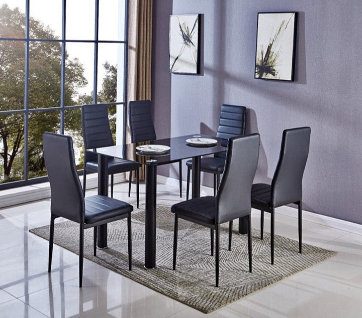 Comedor moderno con una mesa de cristal, seis sillas negras y obras de arte abstracto. Los grandes ventanales dejan pasar la luz natural, lo que realza el ambiente elegante.